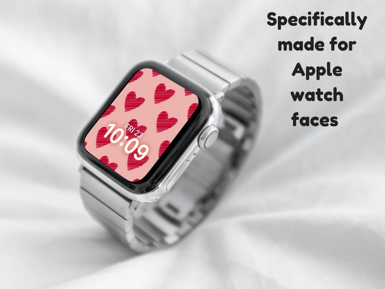 May include: A silver Apple Watch with a pink watch face featuring a pattern of red hearts. The watch face displays the time as 10:09 and the date as FRI 23.