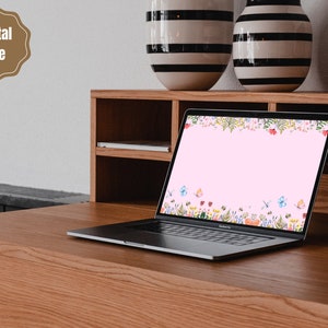 May include: A laptop computer with a pink background and a floral border with butterflies. The laptop is on a wooden desk with two striped vases.