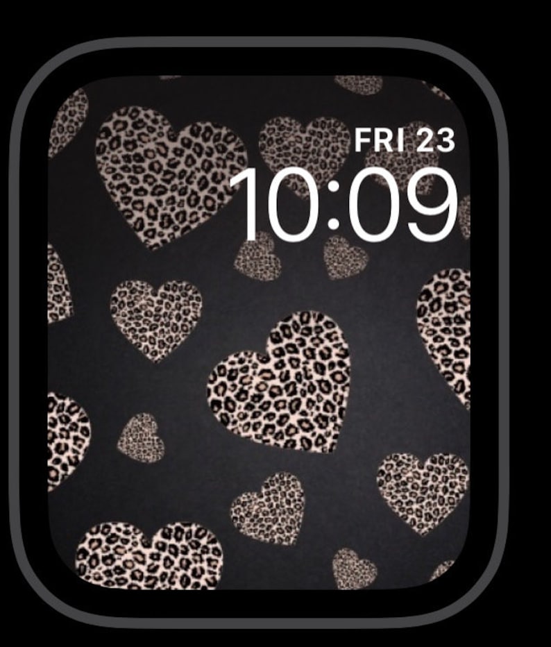 K&ouml;nnte beinhalten: Ein schwarzes Apple Watch-Zifferblatt mit einem Leopardenmuster-Herz-Muster und der angezeigten Uhrzeit 10:09. Das Datum ist FRI 23.