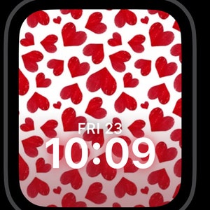 May include: A white Apple Watch face with a red heart pattern and the time 10:09 displayed. The date is displayed as FRI 23.