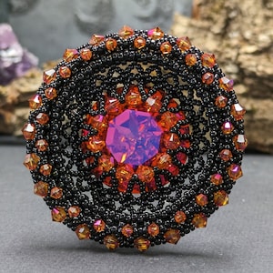 Gothic pendant with lots of glitter and a rivoli in the color astral pink. Focus piece for a necklace in red, orange and black.