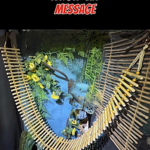 Puede incluir: Un juguete colgante de bamb&uacute; y cuentas para reptiles o animales peque&ntilde;os. El juguete mide 132 cm de largo y se muestra colgado en un terrario con plantas verdes.  "REQUEST A CUSTOM LENGTH VIA MESSAGE" y "EXAMPLE SHOWN - 52" OA" est&aacute;n escritos en rojo sobre un fondo negro.