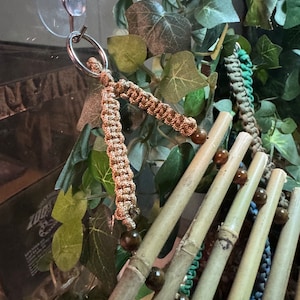 Puede incluir: Un juguete para p&aacute;jaros de bamb&uacute; natural con cuerdas de colores y cuentas de madera. El juguete est&aacute; unido a una ventosa para colgarlo f&aacute;cilmente.