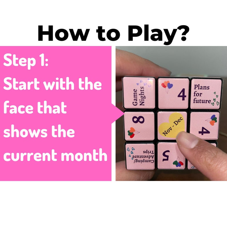 May include: A pink and black cube with different numbers and words on each side. The cube is being held by a hand and the side showing is labelled "Nov-Dec". The instructions for the game are written on a pink background and say "Start with the face that shows the current month."