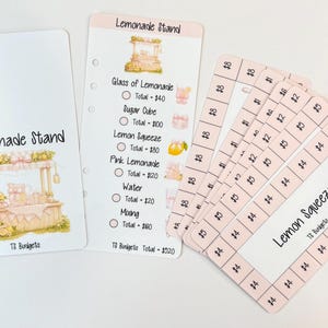 Puede incluir: Insertos de planificador blancos con texto "Lemonade Stand" e ilustraciones. Incluye una lista de ingredientes de limonada y precios, además de tarjetas rosas con gráficos de limón y cantidades en euros.