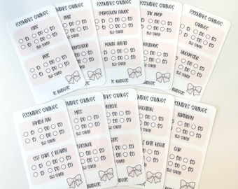 May include: A collection of white and pink budget stickers with various categories like "Kids," "Debt," and "Emergency Funds." Each sticker has circles for tracking savings goals of $5, $10, and $15, with a bow graphic at the bottom.