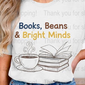 Puede incluir: Camiseta blanca con el texto "Books, Beans & Bright Minds" en azul marino, marrón y amarillo. Una taza de café y libros ilustrados debajo. Prenda de vestir informal.
