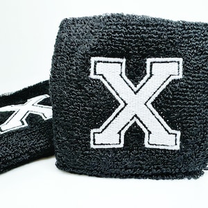 May include: Two black wristbands with a white embroidered letter X on each.