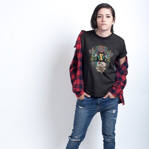 May include: Black t-shirt with a colorful graphic of two hands shaking with a floral design and the text "The Embrace of Freedom".