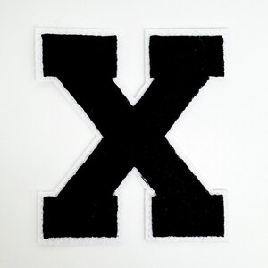 May include: A black letter "X" patch with a white border, set against a white background. The patch has a bold, block letter design, suitable for various crafting projects or personalization.
