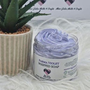 May include: A jar of Parma Violet Whipped Soap with a swirl of lavender-coloured soap on top. The jar has a label with the product name and the Miss Jules Melts & Crafts logo. A potted succulent is in the background.