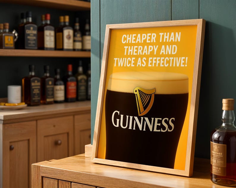 Może przedstawiać: Oprawiony plakat z logo Guinness i kuflem stoutu. Plakat zawiera tekst "CHEAPER THAN THERAPY AND TWICE AS EFFECTIVE!" na ż&oacute;łtym tle. Rama jest jasnobrązowa.