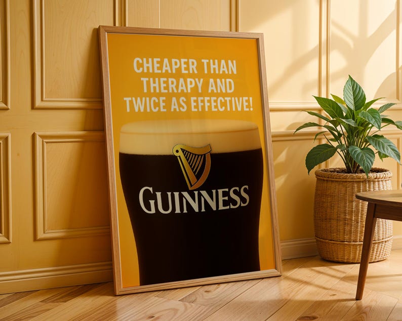 Może przedstawiać: Oprawiony plakat Guinness z kuflem stoutu, z logo marki i napisem "CHEAPER THAN THERAPY AND TWICE AS EFFECTIVE!". Plakat jest prezentowany na ż&oacute;łtym tle, z drewnianą ramą.