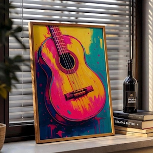 May include: A framed, colorful painting of an acoustic guitar. The artwork features vibrant pink, yellow, and blue hues. A bottle of wine and a stack of books are next to the painting.