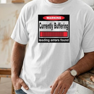 K&ouml;nnte beinhalten: Ein wei&szlig;es kurz&auml;rmeliges T-Shirt mit einer schwarzen rechteckigen Grafik auf der Brust. Die Grafik enth&auml;lt ein rotes Oval mit dem Text WARNING, die Worte Currently Buffering, einen roten Ladebalken und den Text loading errors found darunter.
