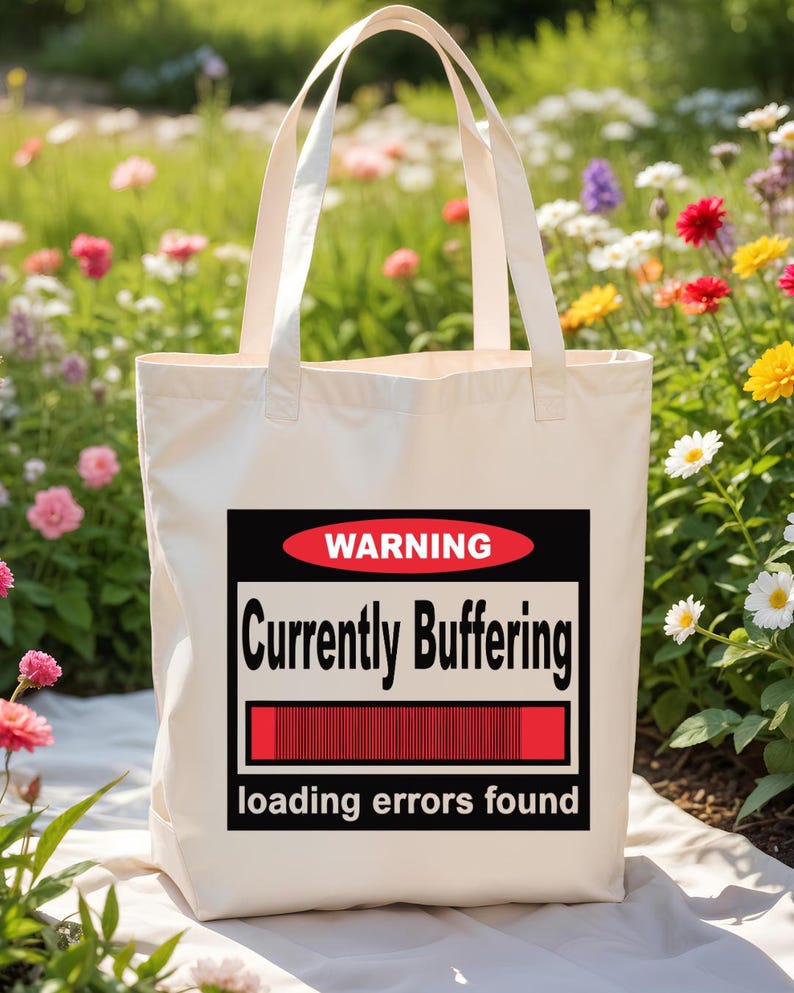 K&ouml;nnte beinhalten: Eine cremefarbene Stofftasche mit einer rechteckigen Grafik, die ein rotes Oval mit dem Wort WARNING, den Text Currently Buffering, einen roten Ladebalken und den Text loading errors found am unteren Rand enth&auml;lt.