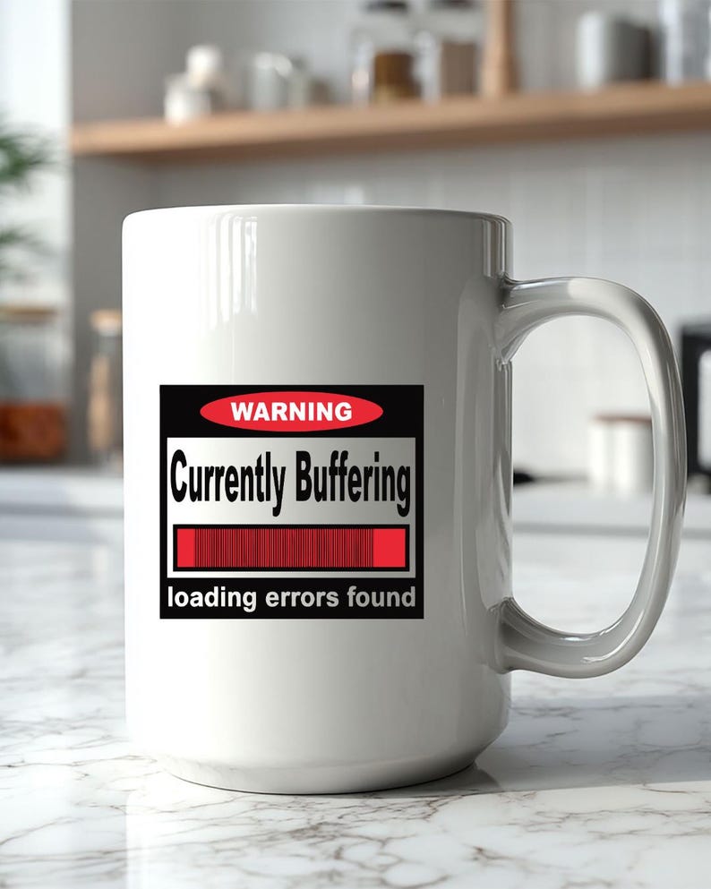 K&ouml;nnte beinhalten: Ein wei&szlig;er Keramikbecher mit einer rechteckigen Grafik, die ein rotes Oval mit dem Wort WARNING, den Text Currently Buffering, einen roten Ladebalken sowie den Text loading errors found in schwarzer und wei&szlig;er Schrift auf der Vorderseite zeigt.