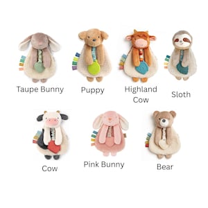 May include: A collection of plush animal toys, including a taupe bunny, puppy, highland cow, sloth, cow, pink bunny, and bear. Each toy has a soft, textured body, a colorful tag, and a small, attached teether.