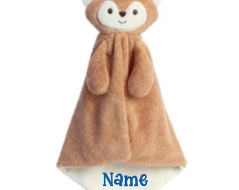 May include: A plush fox security blanket featuring a soft brown and cream-colored fabric. The fox head has embroidered facial features and pointed ears. The bottom corner of the cream-colored fabric section displays the word Name in blue text.