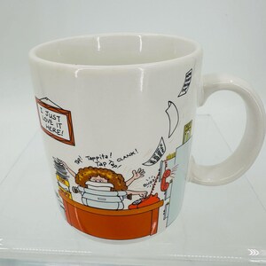 以下が含まれることがあります： 茶色の巻き毛の人物がデスクでタイピングをしているカラフルな漫画イラストが描かれた白いセラミック製のマグカップ。グラフィックには、フレームに入った「I JUST LOVE IT HERE!」というテキストと、「Tap!」や「CLANK!」といった擬音が含まれています。