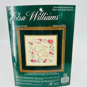 May include: Elsa Williams counted cross stitch kit. The kit features a framed design with the text "I am a Child of God" surrounded by red flowers. The finished size is 10" x 10" (25cm x 25cm).