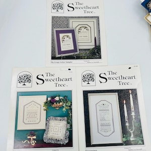 May include: Three cross-stitch pattern booklets from "The Sweetheart Tree" featuring framed sampler designs. The booklets showcase various framed needlework projects, including "The Grape Arbor Sampler" and "Flouressence".