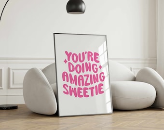 May include: A framed print with a white background and pink text that reads "You're doing amazing sweetie".