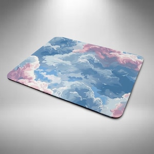 May include: A rectangular mouse mat with a colourful illustration of a cloudy sky. The design features fluffy white, pink, and blue clouds against a blue background. The mouse mat has a smooth surface and a black border.