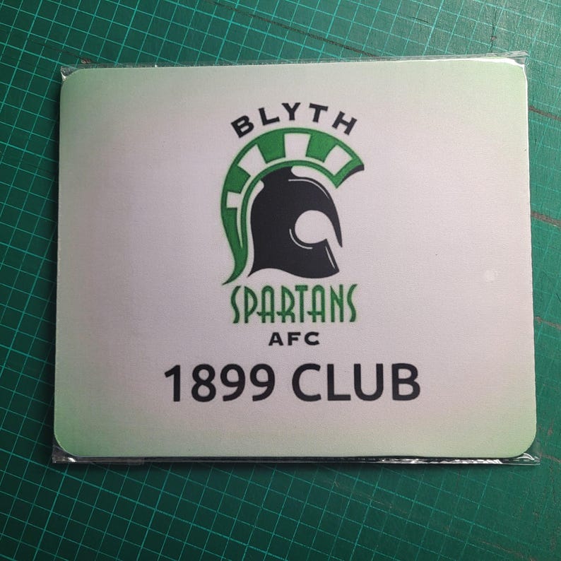 May include: Square mousepad with the Blyth Spartans AFC logo. The logo features a black Spartan helmet with green accents, the word "SPARTANS" and "1899 CLUB" in black text. The background is white with a green gradient.