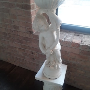 Vintage Neoclassical Plaster/Limestone Off White Pillar Pedestal with a Boy Holding a Bird Bath on Top and Floral Decorations Statue