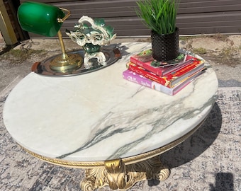 Una fabulosa mesa de centro redonda asequible con cubierta de mármol de Carrara blanco y gris con intrincadas decoraciones de madera y dorados e inserto redondo de mármol.