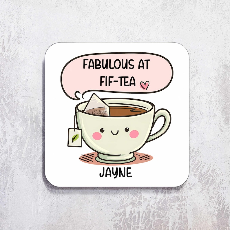 Puede incluir: Posavasos cuadrado blanco con un dise&ntilde;o de taza de t&eacute; de dibujos animados. La taza de t&eacute; est&aacute; llena de t&eacute; y tiene una bolsita de t&eacute;. El texto "FABULOUS AT FIF-TEA" est&aacute; en un bocadillo encima de la taza, con el nombre "JAYNE" debajo.