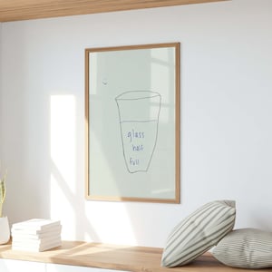 Może przedstawiać: Wydruk w ramie z jasnozielonym tłem i ręcznie rysowanym obrazkiem szklanki wody. Szklanka jest opisana jako "szklanka do połowy pełna".