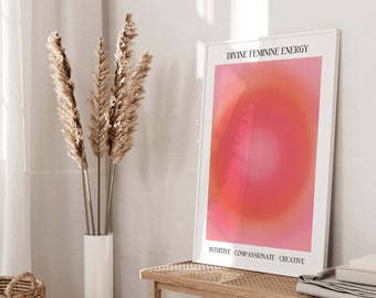 May include: A white framed print with the text "Divine Feminine Energy" and a pink and orange gradient background. The text "Intuitive - Compassionate - Creative" is at the bottom of the print.