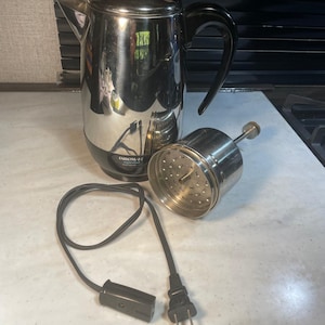 May include: A stainless steel Farberware electric coffee percolator with a black handle and lid. The filter basket and power cord are separate. The percolator is on a white countertop.