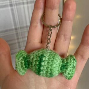May include: A green crocheted candy keyring with a silver metal key ring.