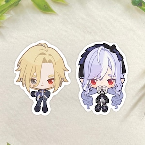 May include: Two chibi-style stickers featuring anime characters. One has blonde hair and a dark outfit, the other has lavender hair and a black dress. Both have red eyes and are set against a neutral background with green foliage.