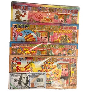 May include: A stack of four red, yellow, and gold Chinese paper money offerings with the text "捌拾億圓頂才捌拾圓" and "天地銀行具才創拍創制属億圓" on the front. The offerings are wrapped in clear plastic.