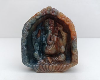 Puede incluir: Una talla de piedra multicolor del dios hindú Ganesha. La talla es detallada e intrincada, con un fondo colorido y arremolinado.