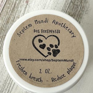 May include: A white ceramic mug with a black handle and the text "But First, Coffee" in a black, handwritten-style font. The mug is on a white surface.