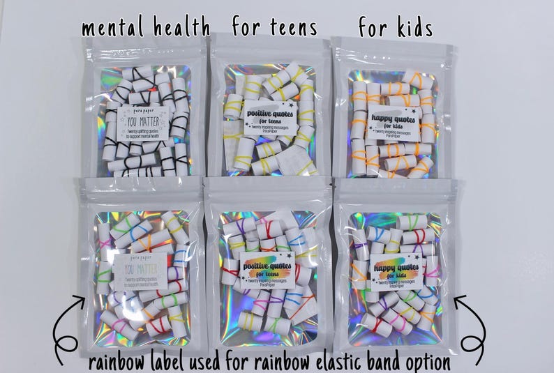May include: Six clear holographic pouches containing rolled paper scrolls secured with elastic bands. Labels read: mental health, you matter, positive quotes for teens, happy quotes for kids, and rainbow label used for rainbow elastic band option.