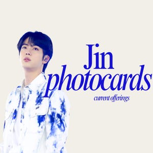 May include: A promotional image for Jin photocards. The image features a person wearing a white denim jacket with blue tie-dye patterns. The text "Jin photocards" is in blue, with "current offerings" below.