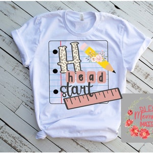 May include: White t-shirt featuring a graphic design of a pencil, ruler, and the words "Head Start" on a sheet of notebook paper. The graphic is in a school theme with leopard print, flowers, and a pink ruler.