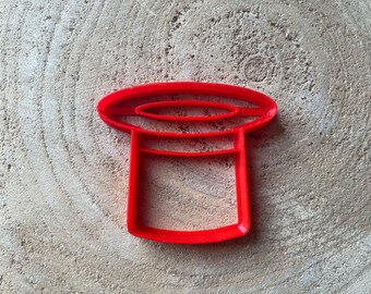 May include: Red plastic cookie cutter shaped like a top hat.