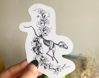 May include: Black and white sticker featuring a skeletal animal with a vine growing up its back. The animal is in a running pose with its head turned to the side. The vine has leaves and berries.