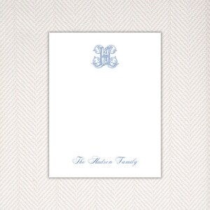 Può includere: Carta da lettere bianca con un monogramma blu ornato della lettera "H" e il testo "The Hudson Family" in scrittura corsiva blu.