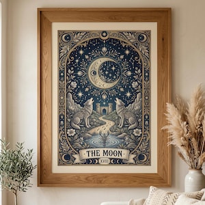 Pode incluir: Impressão emoldurada de uma carta de tarô, com uma lua crescente, estrelas e dois lobos uivando. A obra de arte usa tons de azul, bege e dourado, com as palavras "THE MOON" na parte inferior. A moldura é de madeira.