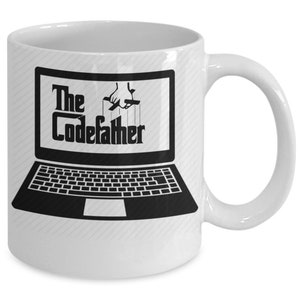 May include: White ceramic mug featuring a black and white image of a laptop with the text "The CodeFather" on the screen. A hand is depicted manipulating the laptop with strings.