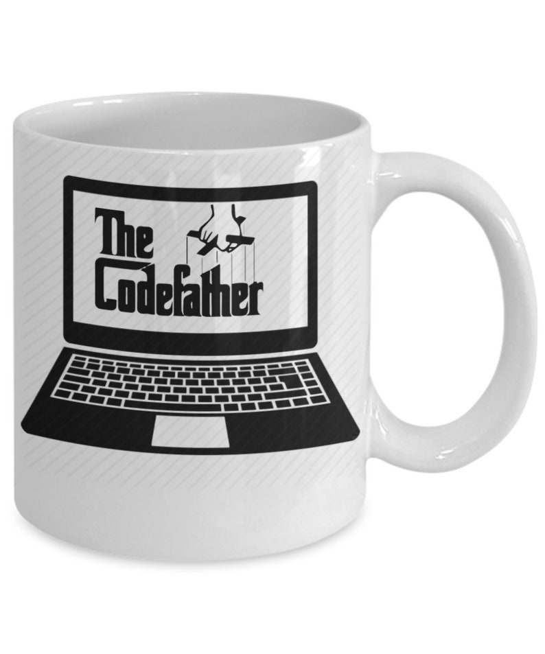May include: White ceramic mug featuring a black and white image of a laptop with the text "The CodeFather" on the screen. A hand is depicted manipulating the laptop with strings.