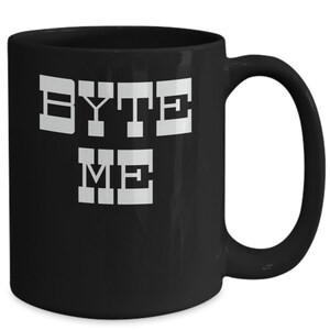 Könnte beinhalten: Schwarze Keramik-Kaffeetasse mit einer weißen Grafik, auf der in einer pixeligen Schrift "BYTE ME" steht.